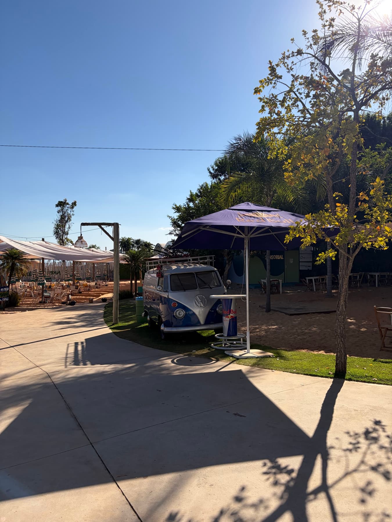 Kombi decorada e guarda-sol na entrada da área de areia